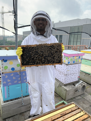 Photo of Lucio N. holding a bee frame