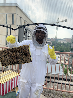 Photo of Zuberi A. holding a bee frame